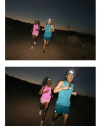 Two runners wearing headlamps running along an unpaved outdoor path at dusk under a dark twilight sky.