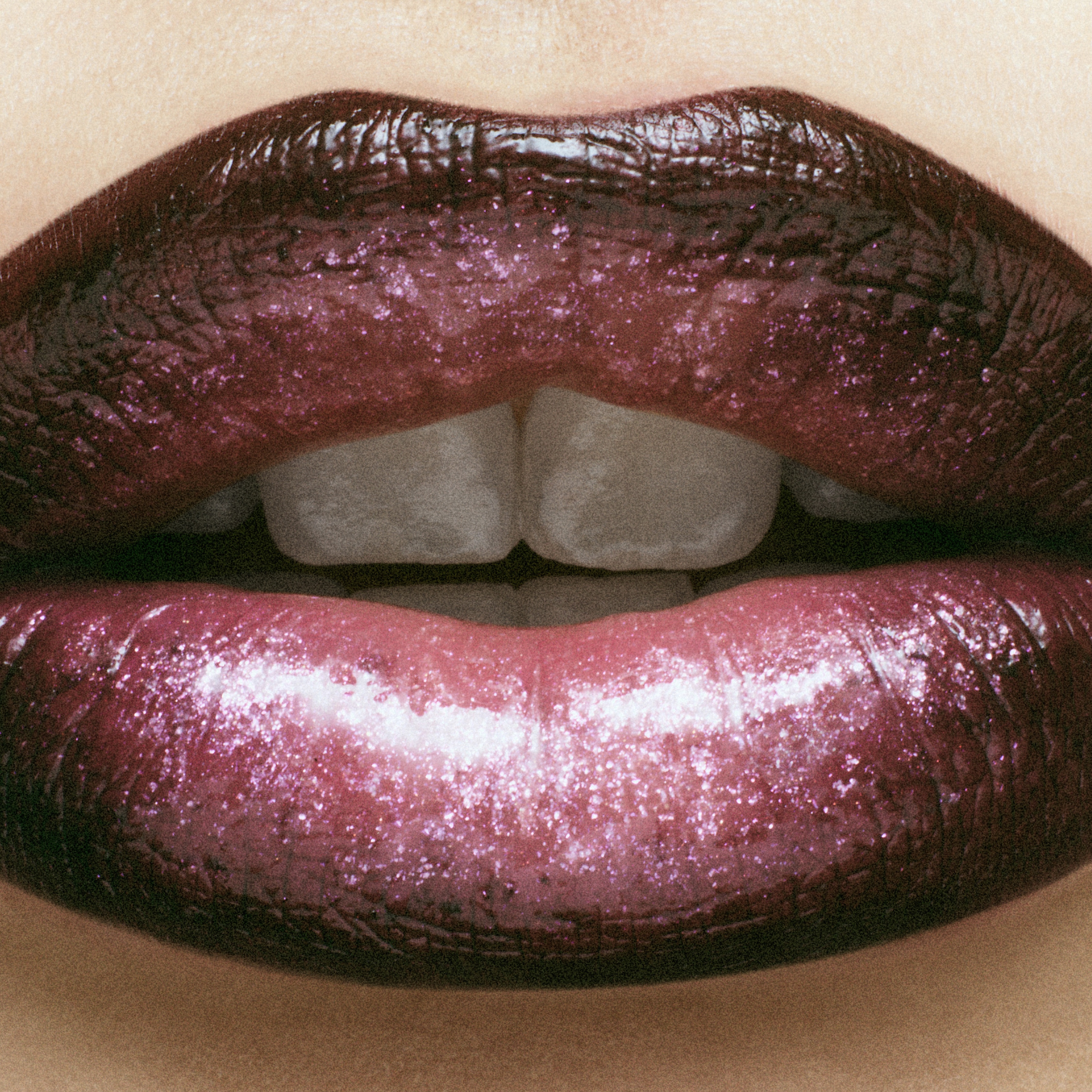 Close-up of a human face featuring lips with a dark, glossy gradient lipstick, showcasing beauty and cosmetic makeup.