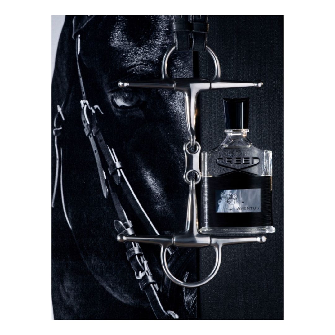 Equestrian-themed fragrance bottle hanging from a horse's bridle against a dark backdrop, highlighting the connection between luxury and equestrian sports.