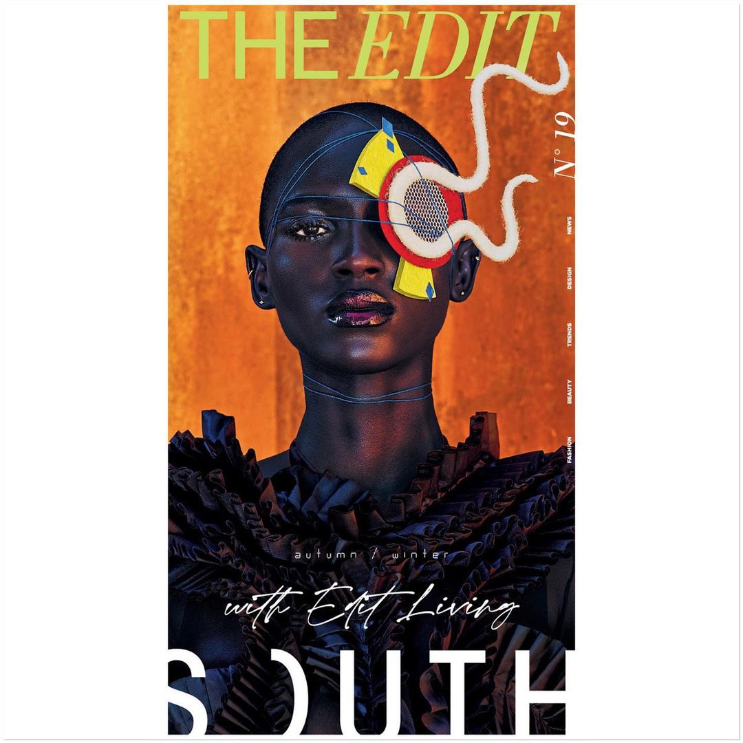 Fashion magazine cover featuring a woman with dark skin, geometric eye makeup, and a black ruffle dress, set against an orange backdrop.