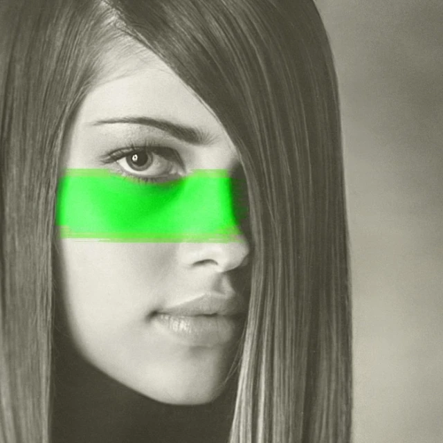 Close up of a woman's face with long straight hair and a band of green masking her eyes in a studio shot.