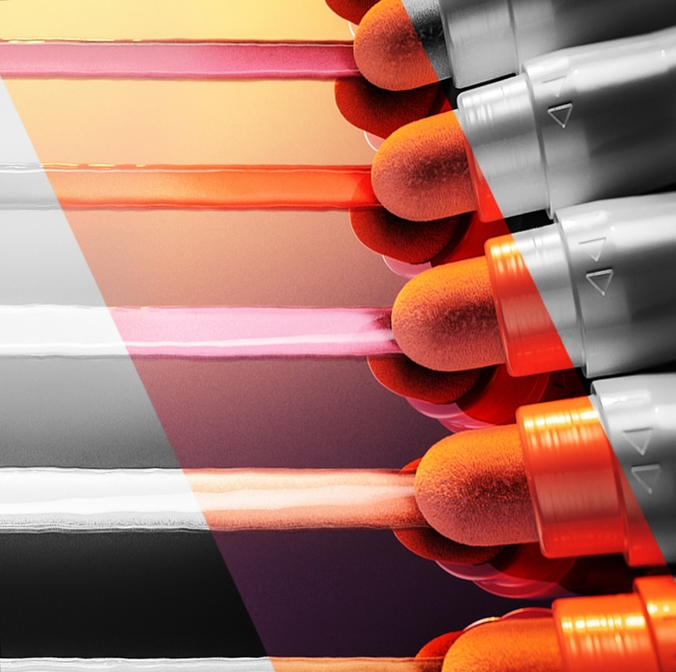 Close-up of orange cosmetic applicators with grey handles against a blurred background of gradient colors ranging from pink to orange.