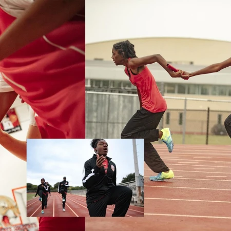 Track and field athletes in relay race exchange baton on outdoor running track in red and black uniforms; sports photography.