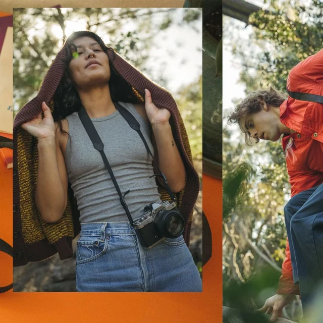 Two people in a natural setting with one wearing a camera and the other in an orange jacket surrounded by foliage.