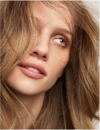 Close-up beauty portrait of a woman with long blonde hair framing her face and glossy lips, captured by Kimber Capriotti.