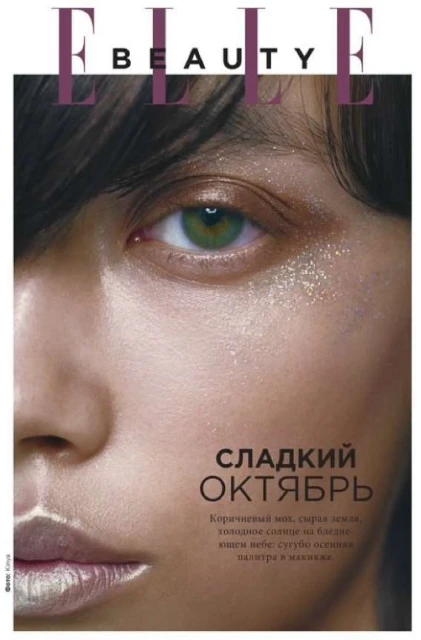 Beauty shot of a woman's face with glittery makeup, showcasing the details of her eye and flawless skin. Magazine cover style.