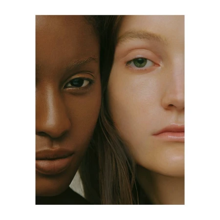 Close-up portrait of two female models with contrasting skin tones positioned side by side.