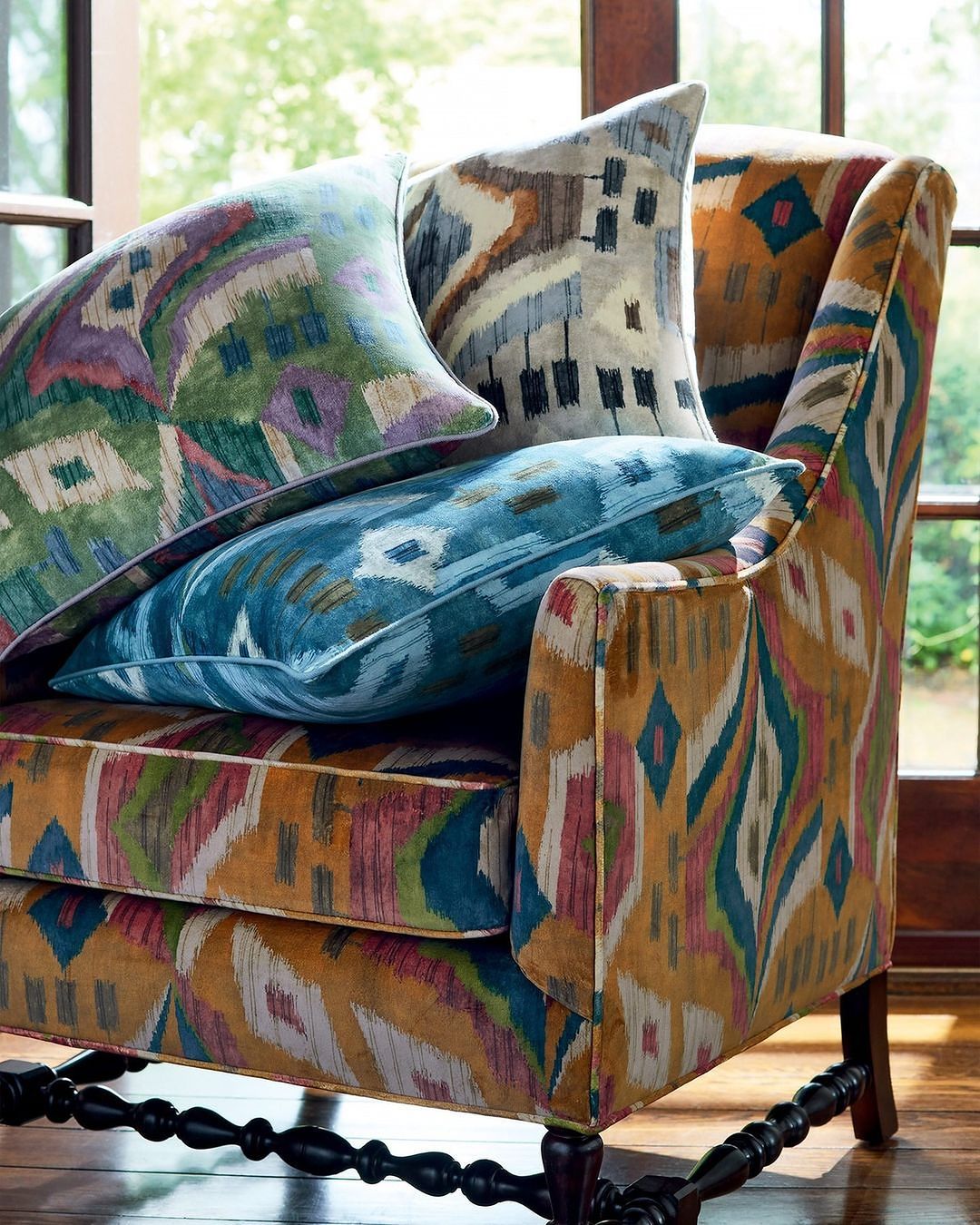 Stylish armchair with patterned upholstery and decorative cushions creating a cozy and inviting indoor furniture arrangement.