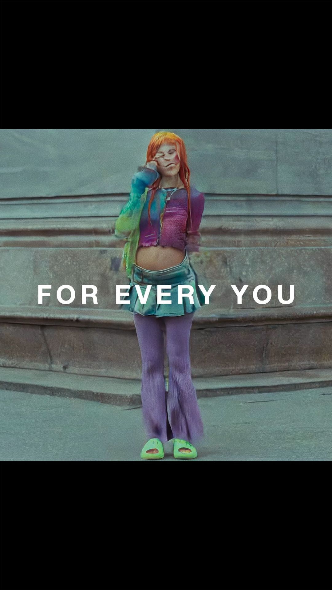 Young adult woman with bright orange hair, wearing a colorful outfit, stands on an urban street, with the text 'FOR EVERY YOU' overlaid.