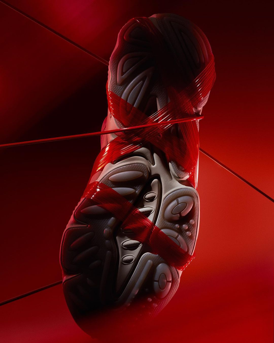 An abstract product shot of a futuristic sneaker-like object wrapped in red string, presented against a matching deep red background.