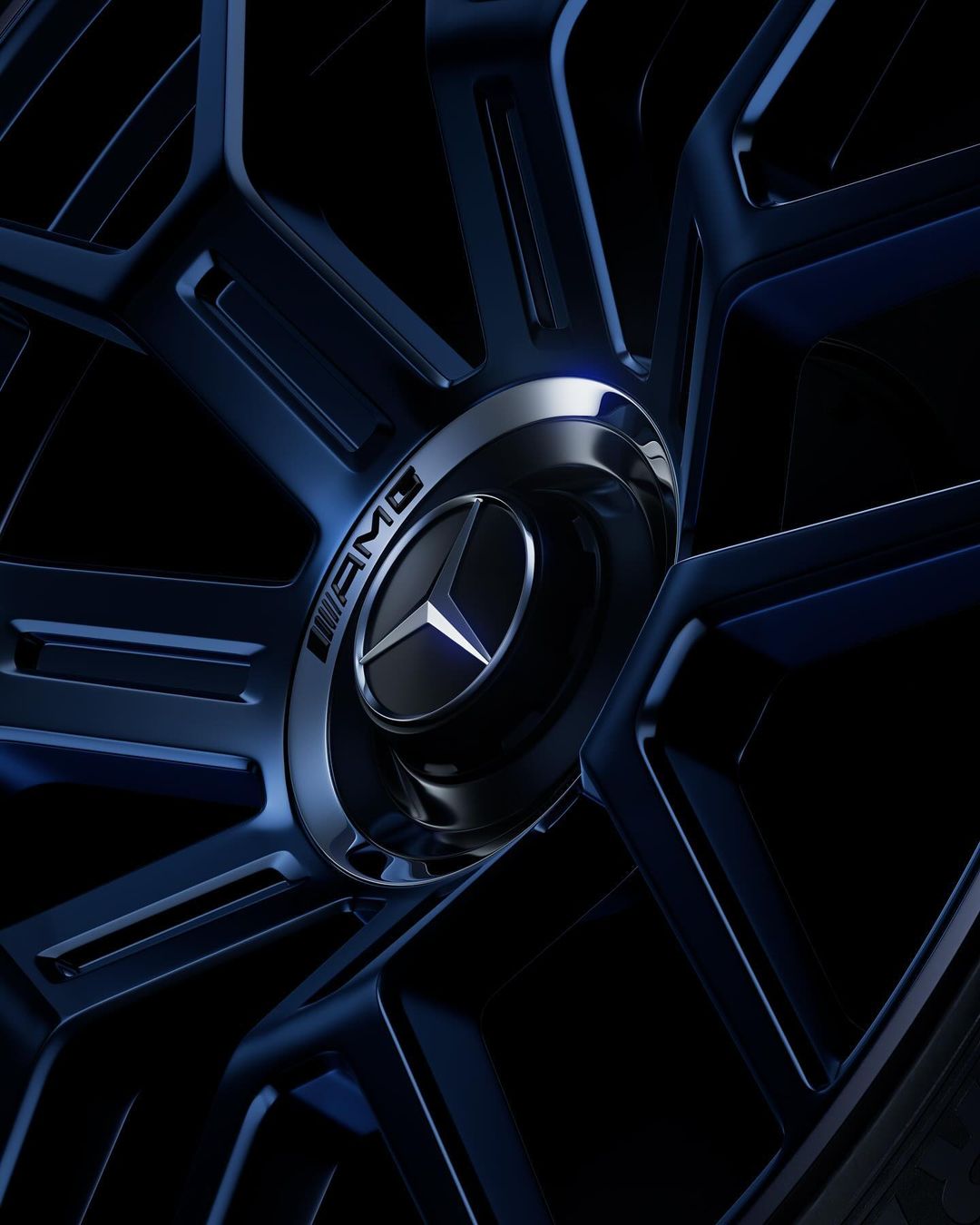 Close-up of a Mercedes-Benz AMG wheel with a blue rim and a silver center cap featuring the iconic three-pointed star logo.