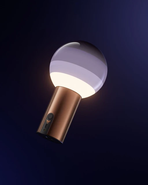 A luminous orb lamp with a copper handle glows against a deep blue background, creating a modern, eye-catching accent light.