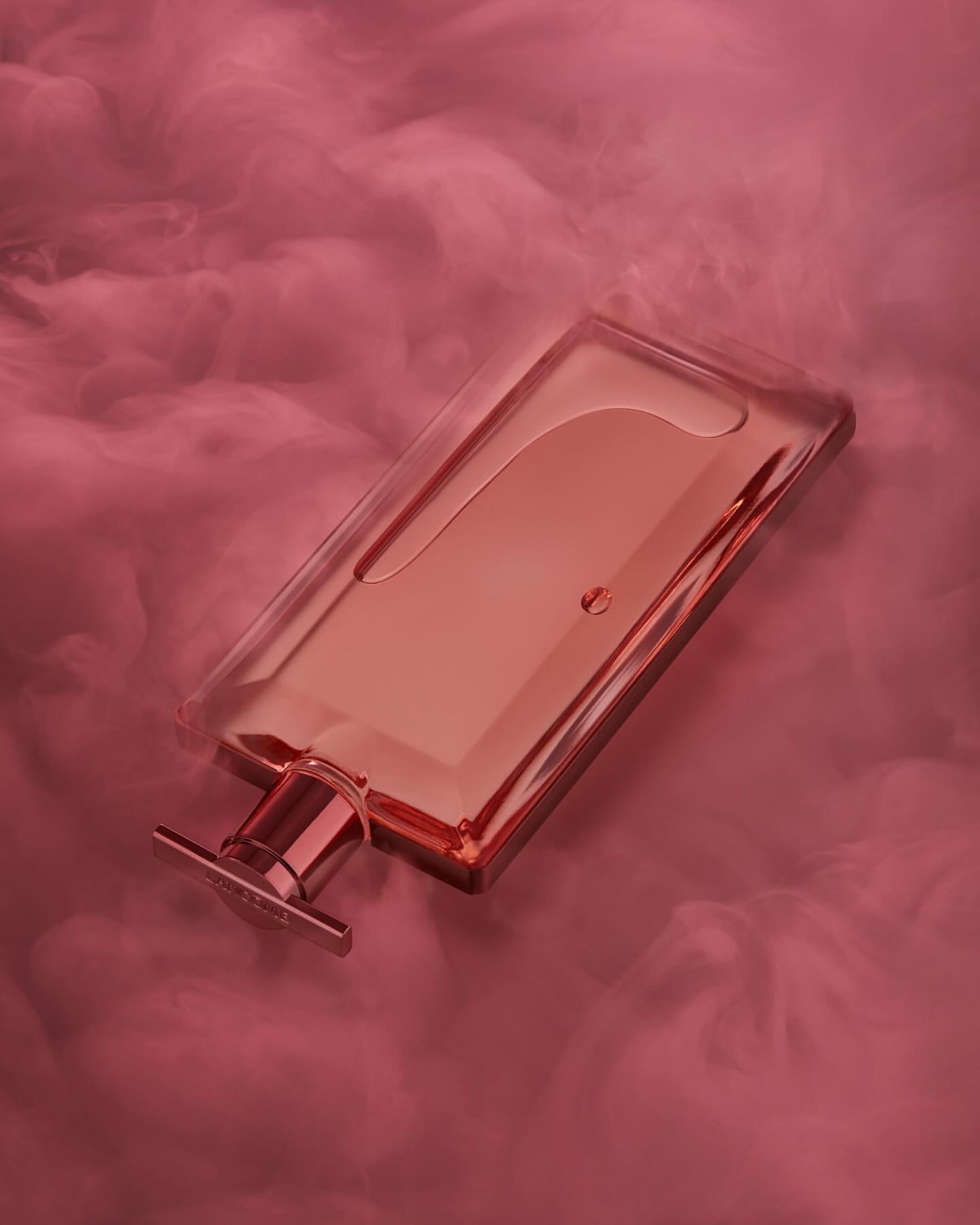 Elegant rectangular glass perfume bottle on its side surrounded by pink clouds, creating a serene and luxurious beauty product image.
