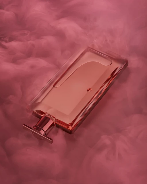Elegant rectangular glass perfume bottle on its side surrounded by pink clouds, creating a serene and luxurious beauty product image.