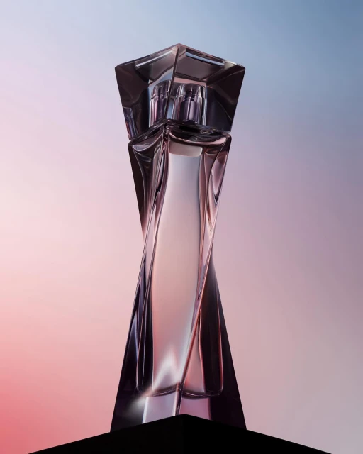 Sleek and modern crystal perfume bottle with a geometric design against a soft gradient background of pink, purple, and blue.
