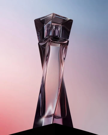 Sleek and modern crystal perfume bottle with a geometric design against a soft gradient background of pink, purple, and blue.