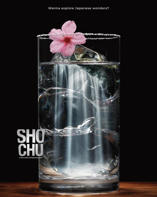 Elegant drink photography featuring a glass of 'Shochu' with ice cubes and a pink cherry blossom, set against a dark background.