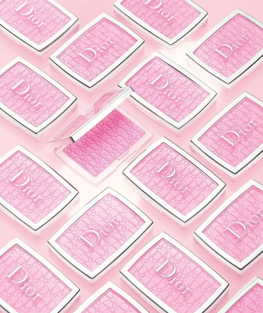 Overhead shot of multiple Dior blush compacts in a light pink hue, neatly arranged on a matching light pink surface.