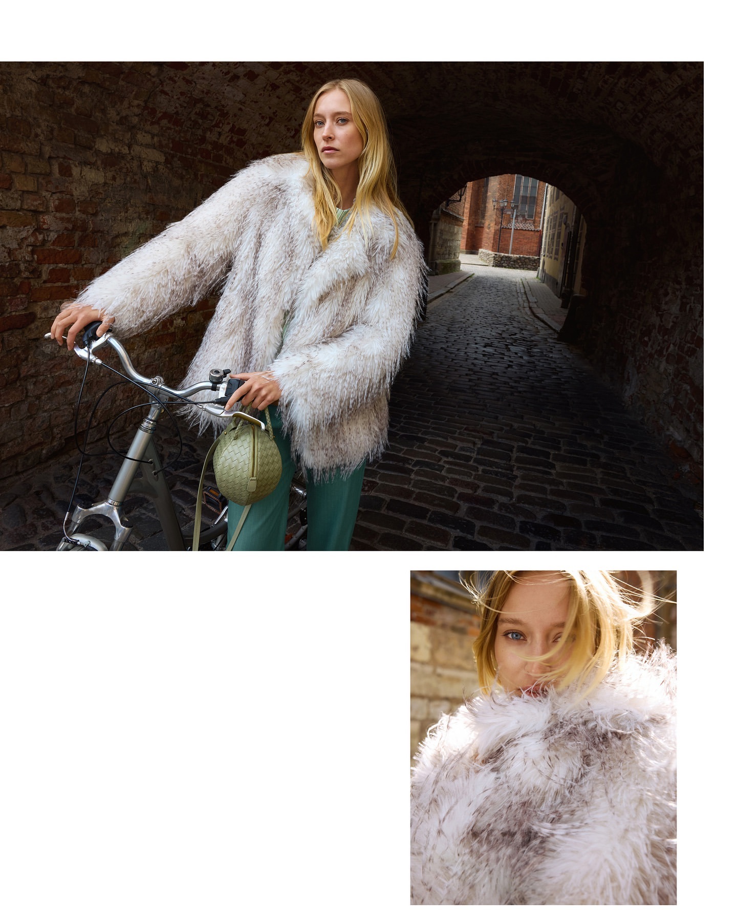 Fashion shot of a woman in a furry coat posing with a bicycle in a brick alleyway with a purse; indoor lighting, medium shot.