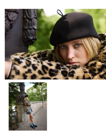 Portrait of a blonde woman wearing a black beret and leopard print coat leaning against a stone pillar in Istanbul by Koray Parlak.