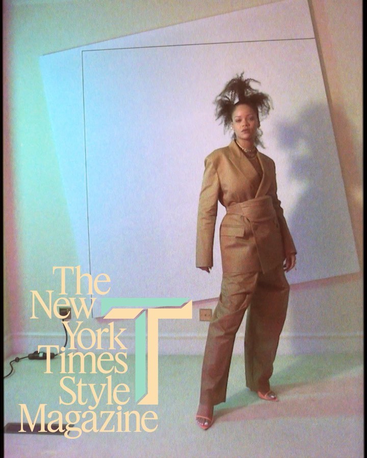 Fashion editorial shot of a woman in a tan suit with high hair standing against a white backdrop, promoting The New York Times Style Magazine.