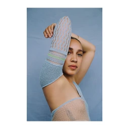 Portrait of a woman wearing a textured blue knit sleeve covering her arm, photographed by Krystal Neuvill.