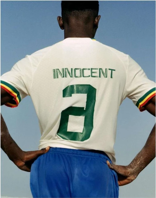 Close-up of an adult man wearing a sports jersey with number '2' on the back, with a clear blue sky in the background.  