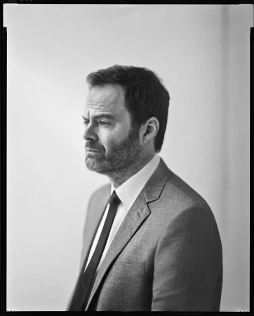 Portrait of Bill Hader in a suit and tie looking to the side against a neutral background by Kwaku Alston