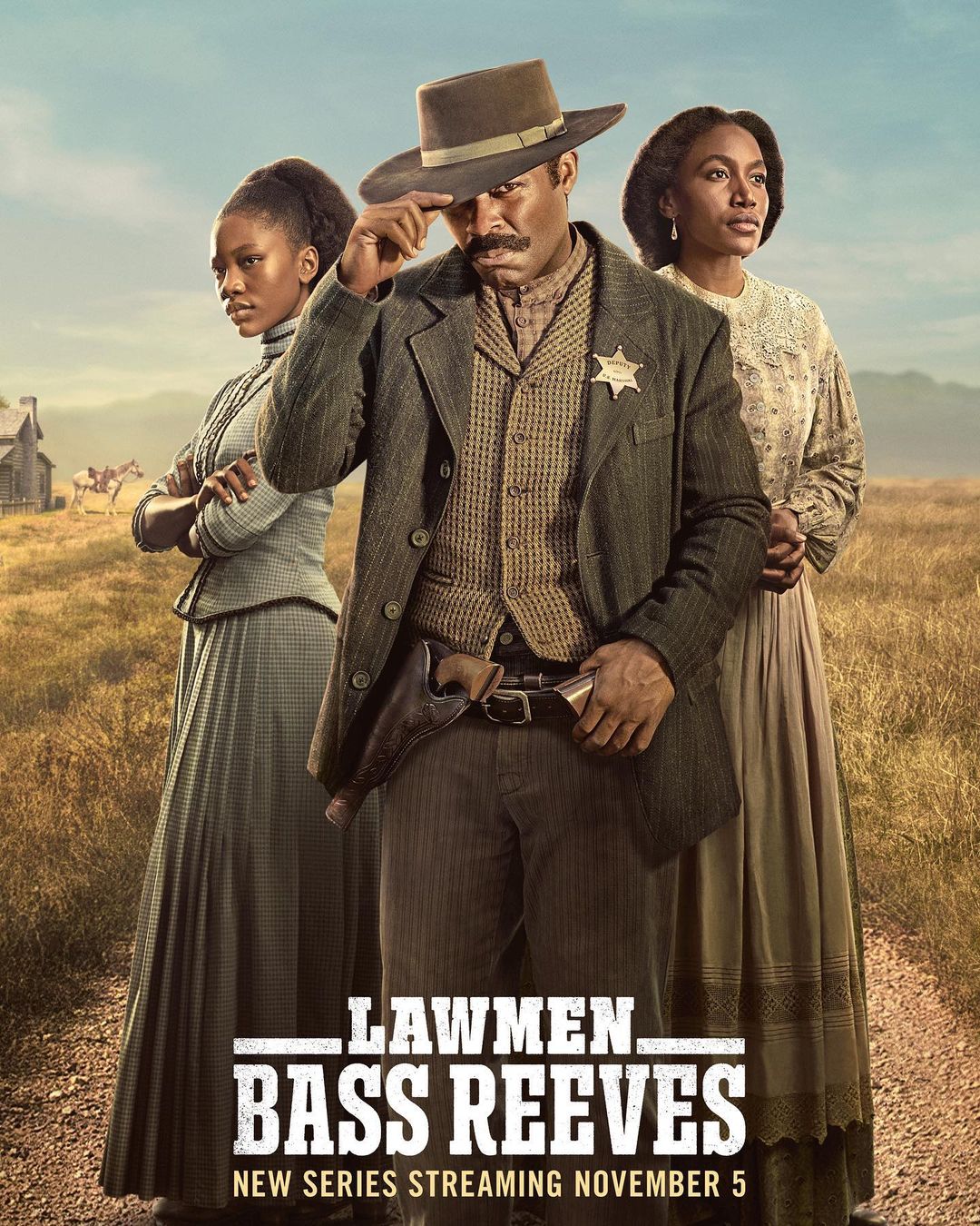 Promotional image for 'Lawmen: Bass Reeves' featuring David Oyelowo with two women in a rural Western setting, with a sheriff's badge.