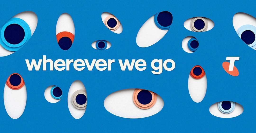 Abstract blue background features layered paper-cut eyes, along with the white sans-serif text 'wherever we go' and the Telstra logo.