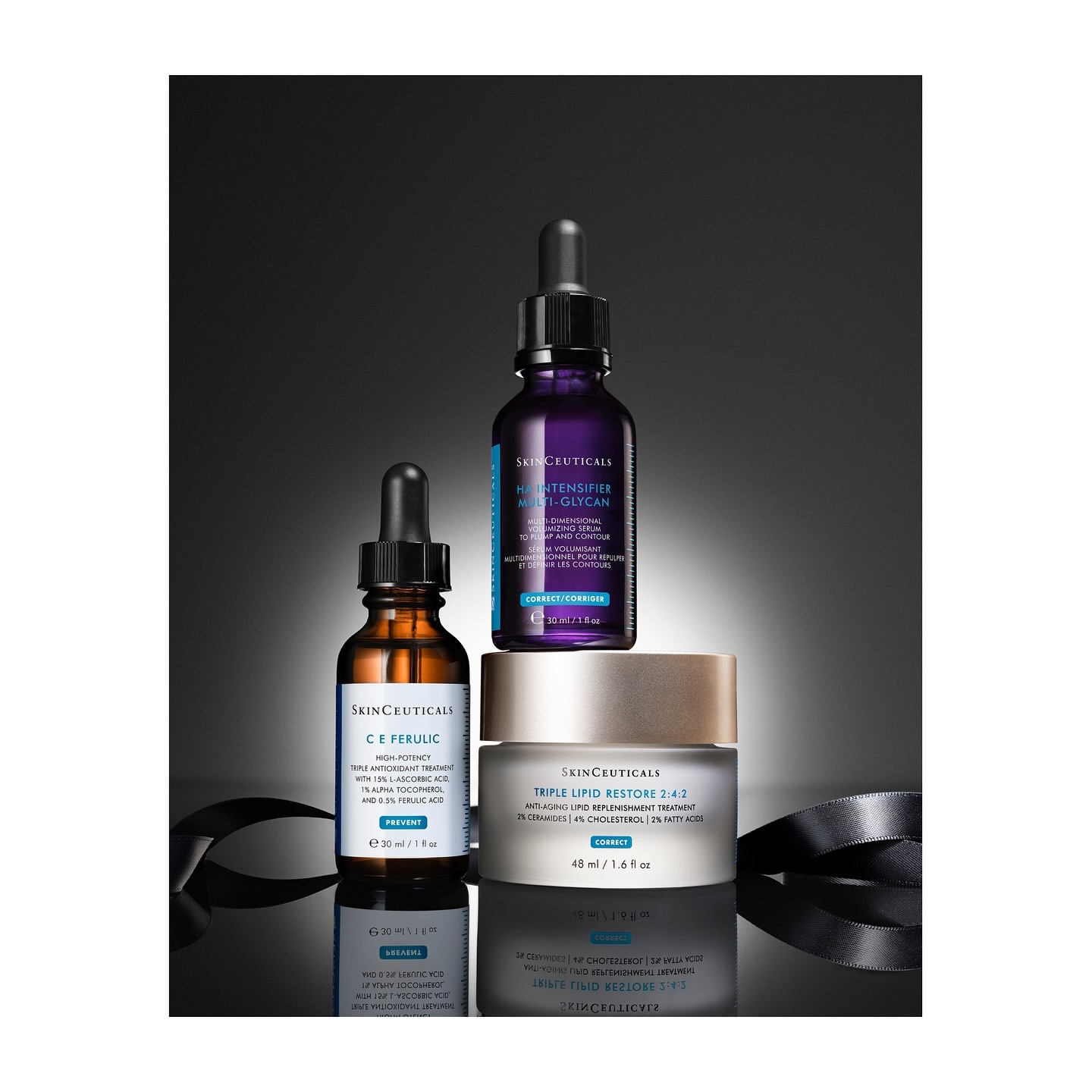 Three SkinCeuticals products including serum and cream on a reflective surface against a gradient dark gray background with ribbon.