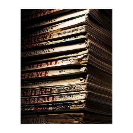 Stack of vintage Popular Science and Mechanics magazines with aged covers, creating a sense of nostalgia and the history of science.