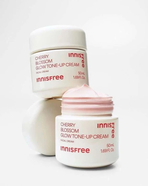 Two white jars of Innisfree Cherry Blossom Glow Tone-Up Cream are stacked against a white background in a beauty product shot.