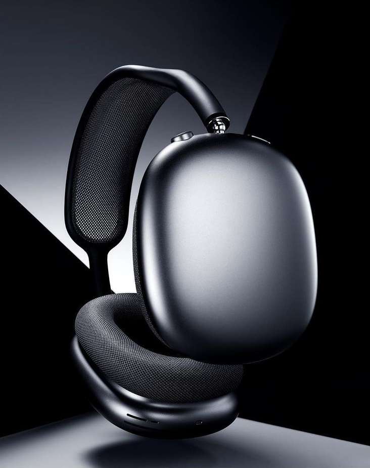 Studio shot of black over-ear headphones with mesh details, showcasing a modern design against a dark, geometric backdrop.
