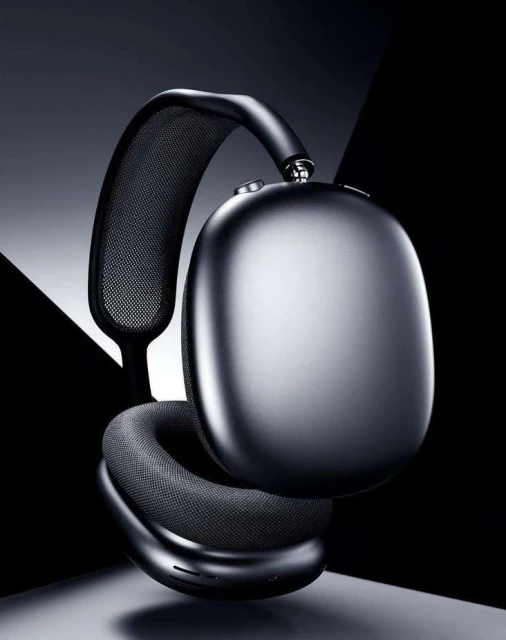 Studio shot of black over-ear headphones with mesh details, showcasing a modern design against a dark, geometric backdrop.