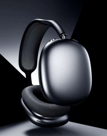 Studio shot of black over-ear headphones with mesh details, showcasing a modern design against a dark, geometric backdrop.