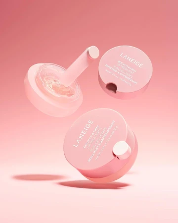 Three jars of Laneige lip treatment arranged against a pink background, showcasing a skincare product for beauty and personal care.