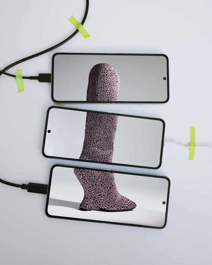 Three smartphones display parts of a textured leg on a white surface, connected by black cables and secured with green tape.