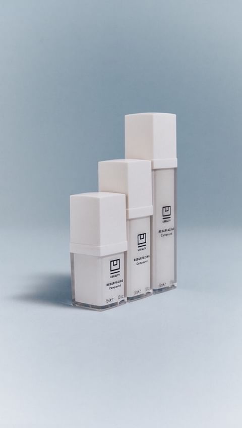Three white cosmetic containers are arranged in ascending order against a light blue backdrop, showcasing minimalist product design.