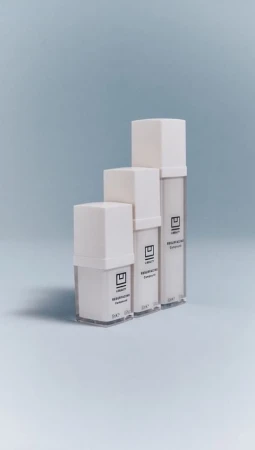 Three white cosmetic containers are arranged in ascending order against a light blue backdrop, showcasing minimalist product design.