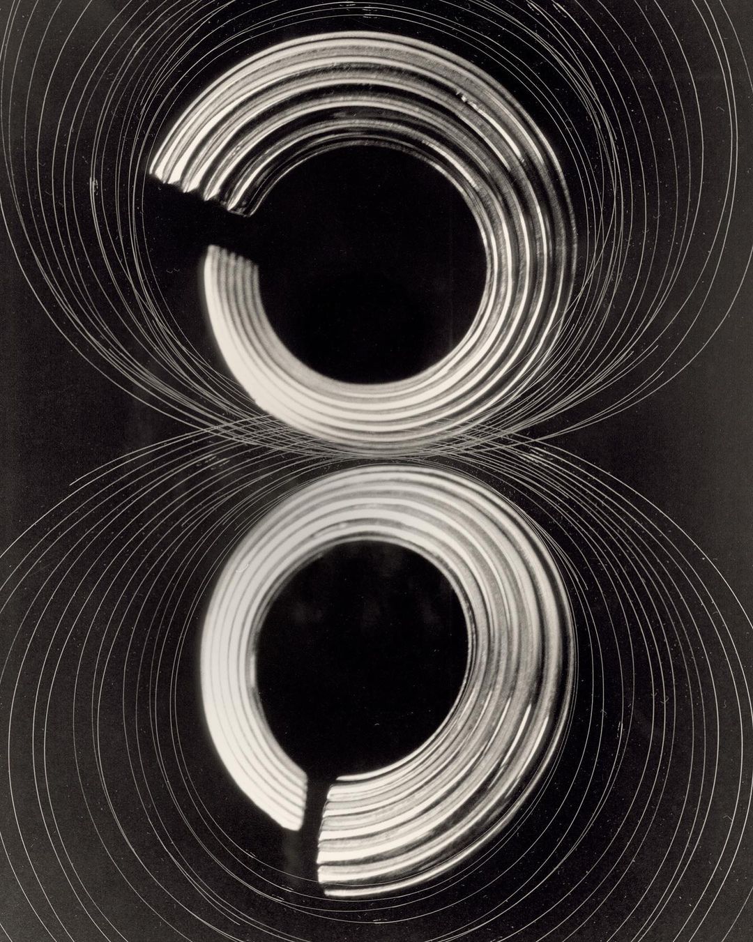 Abstract black and white image of two concentric circles, created with light trails in a dark setting, creating a mesmerizing visual effect.