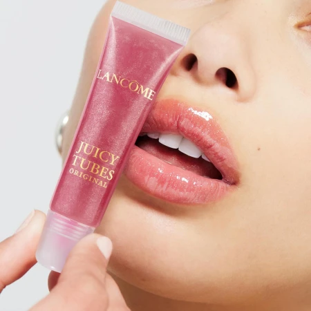 Close-up of lips and hand holding a Lancome Juicy Tubes lip gloss tube, shot by Lara Callahan.