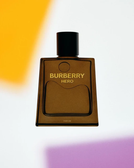 Burberry Hero Parfum bottle on a white surface, featuring a minimalist design, black cap, and transparent, brown-tinted glass.