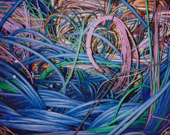 Bundle of blue, green, and pink networking cables creates a colorful tangled pile, filling the frame with technology wires.