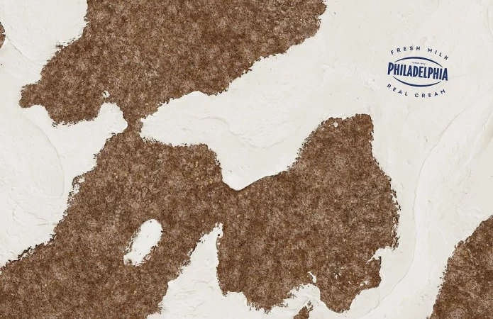 Abstract background of cream cheese and brown texture, with the Philadelphia Cream Cheese logo visible on the upper right.