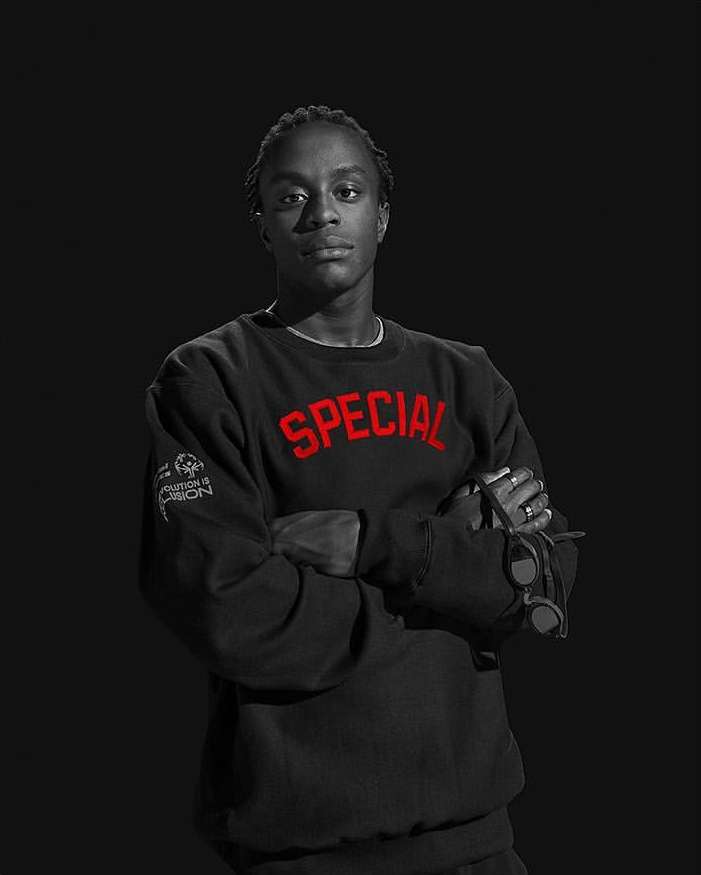 Portrait of adult male with arms crossed, wearing black sweatshirt with the word SPECIAL in red letters against a black background.