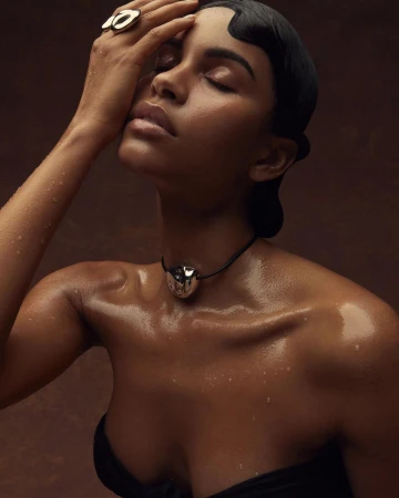 Close-up portrait of a woman with wet skin wearing a silver choker and ring, photographed by Lauren Loncar