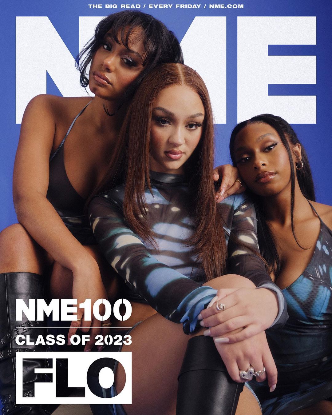 Three women featured on a magazine cover, all close together, posing in front of a blue background with the words NME and FLO in white.