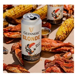 Guinness Blonde beer can surrounded by seasoned crabs and grilled corn on the cob
