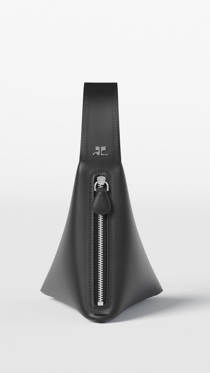 Studio shot of a sculptural black leather handbag with a silver zipper, set against a bright white background. Fashion accessory.